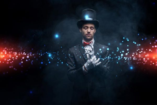 Magicien en costume et chapeau portant des gants dans une pièce sombre et enfumée avec